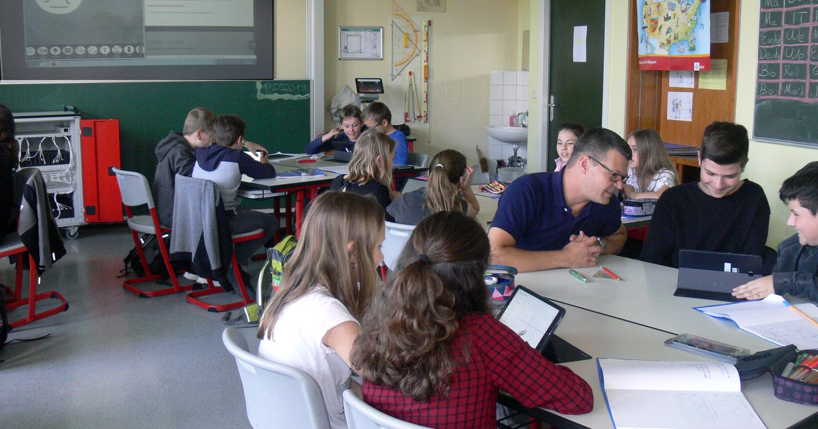 Uczniowie w klasie pracujący na tabletach podczas lekcji geometrii.